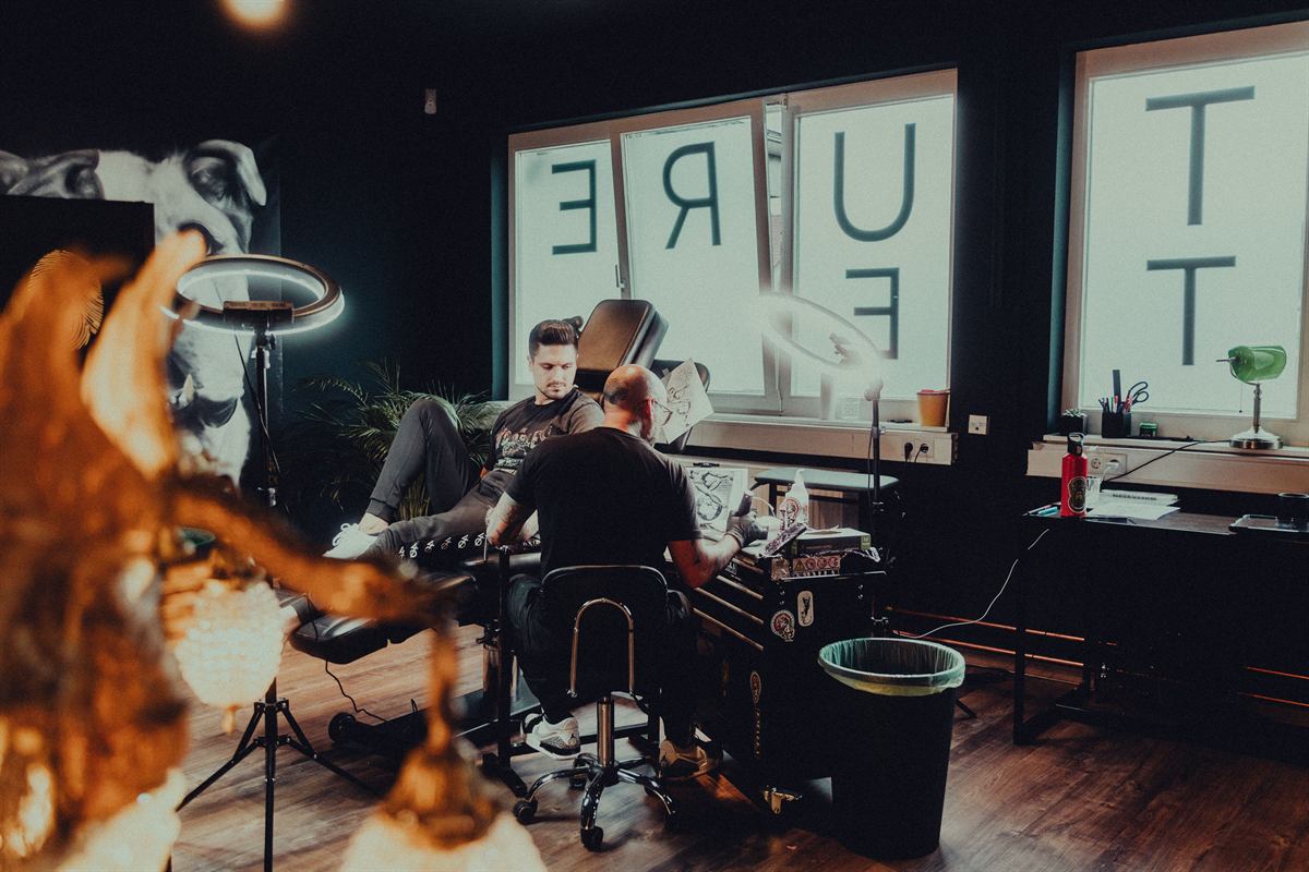 Interior of the studio: an artist working at a private station beside tall frosted windows