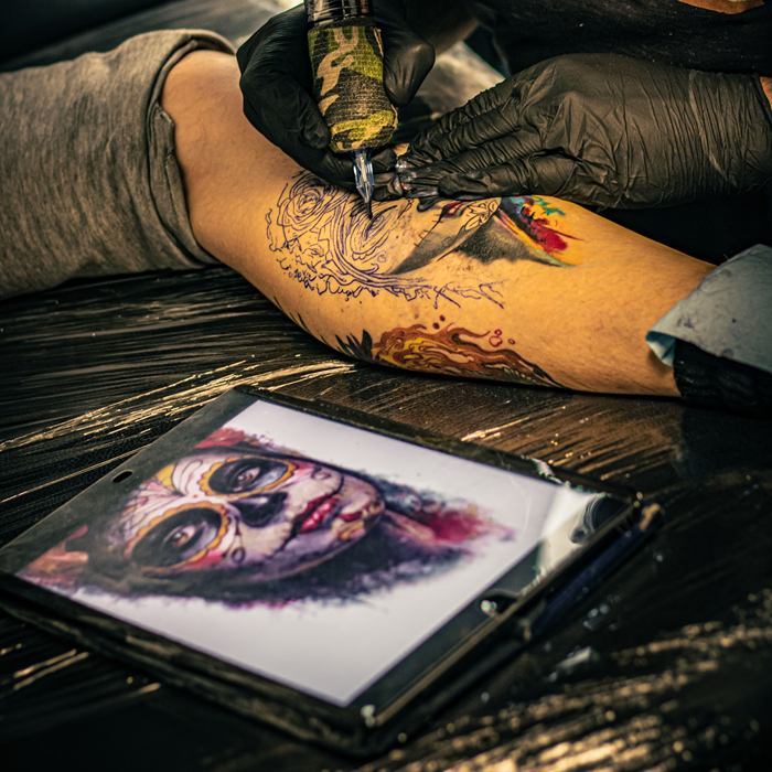 Detail of freehand linework on an arm during a session